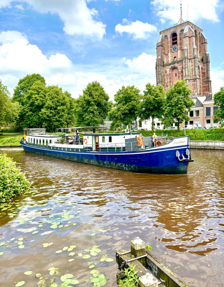 Ship Josefien sailing through Leeuwarden with the leaning Oldehove tower behind
