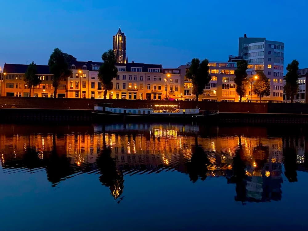 Riverside city lit up at night and reflected in the water on the Hanseatic Route