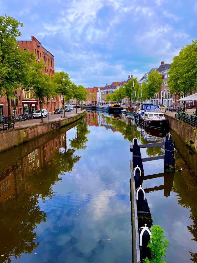 Tree-lined city canal with moored boats on the Northern Provinces route