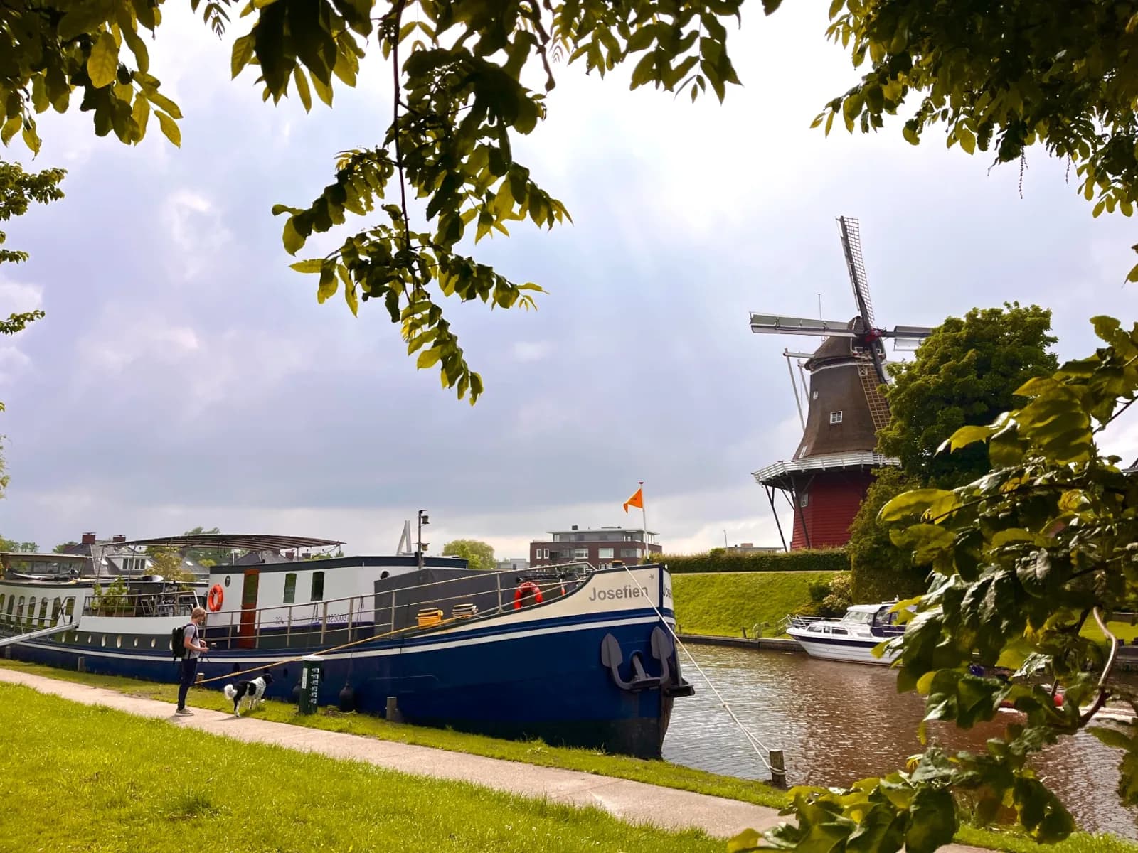 Ship Josefien moored on a grassy bank near a windmill on the Northern Provinces route