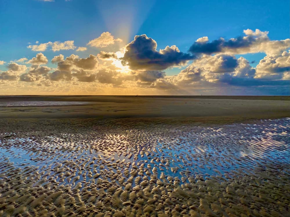 Rippled tidal flats of the Wadden Sea at low tide under an evening sky